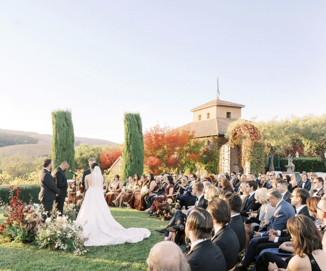 Outdoor wedding ceremony on the lawn with guests seated