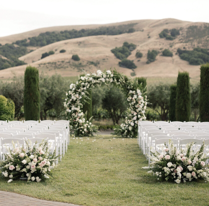 Floral ceremony arch on the lawn overlooking the hills