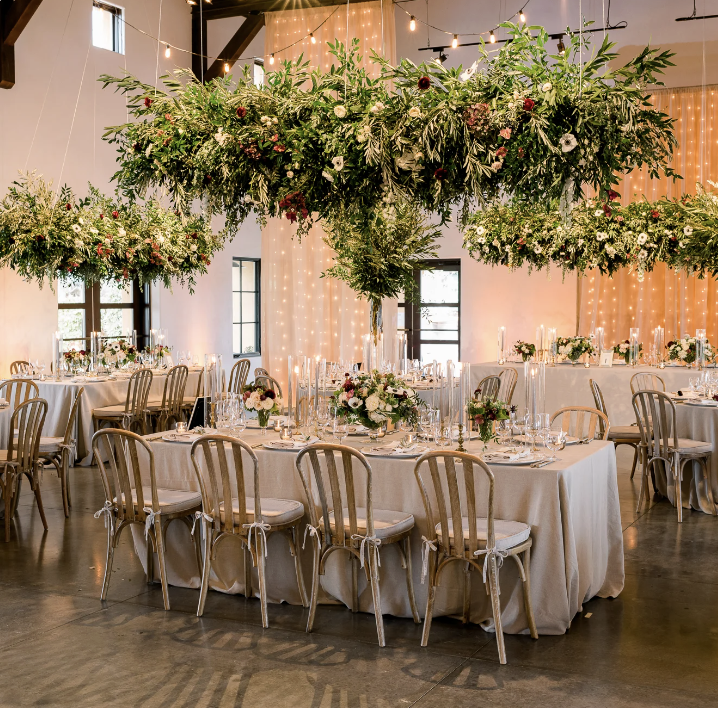 Candlelit reception in the ballroom beneath suspended greenery