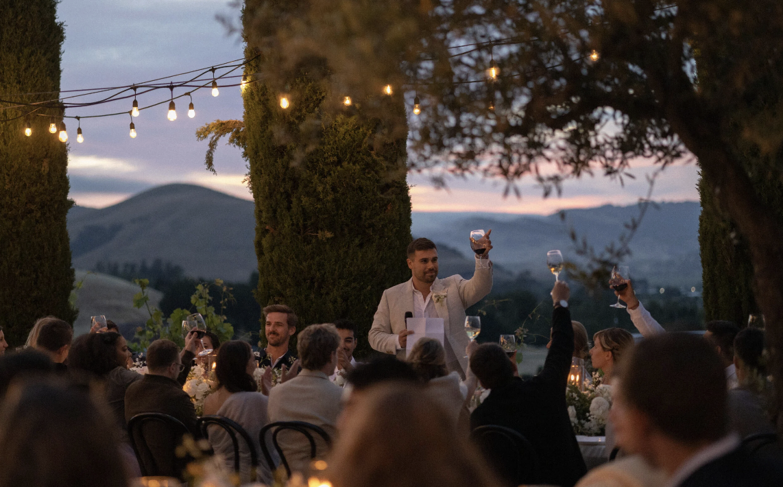 Sunset toast at a candlelit reception among the cypress trees