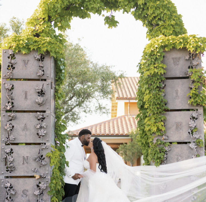 Couple kissing under the ivy-covered Viansa Winery arch