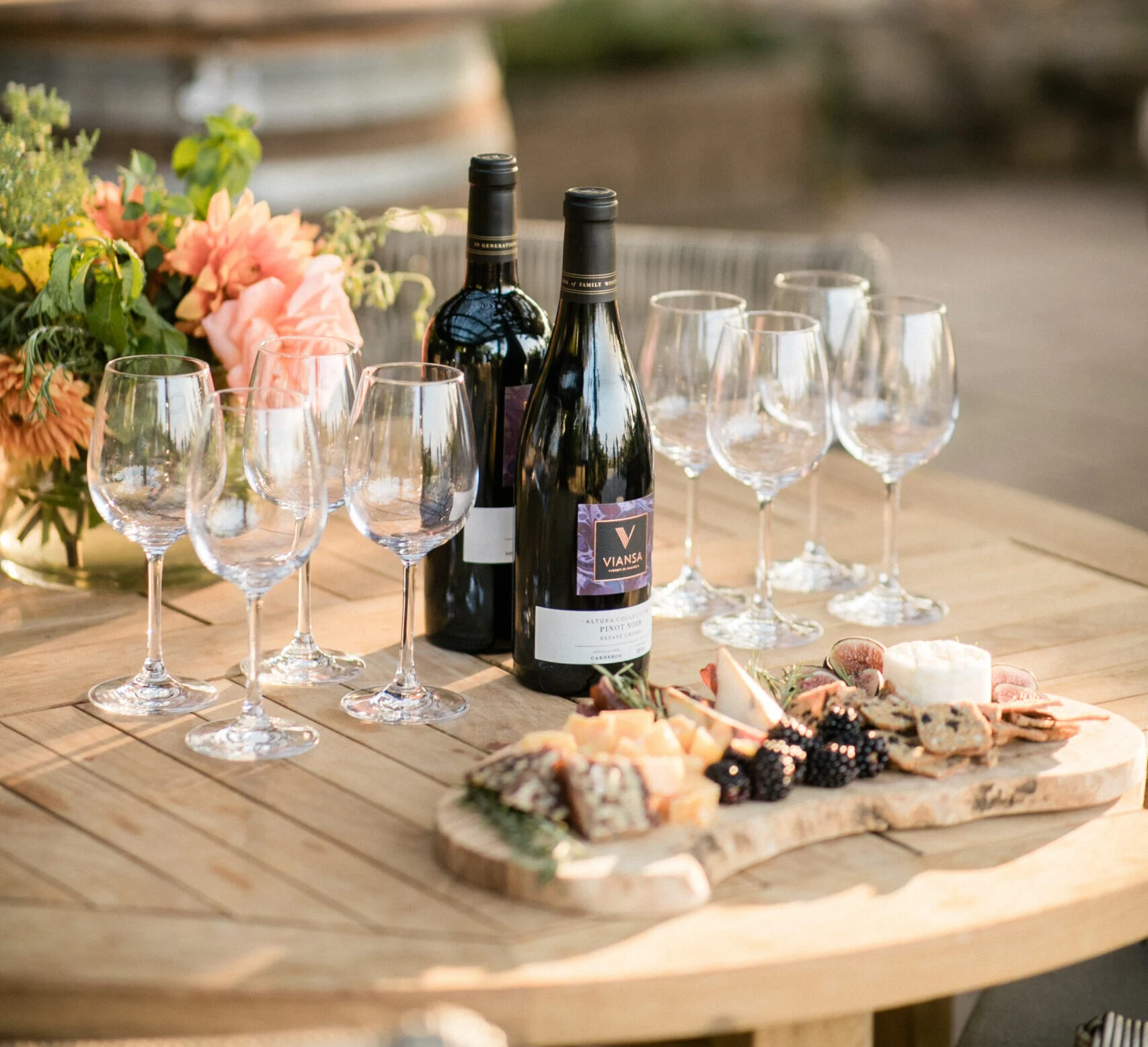 Wine bottles, glasses, and cheese board